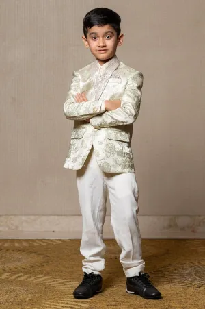 Elegant brocade suit jacket with floral patterns paired with crisp white trousers and a classic ivory shirt for a regal and sophisticated look.