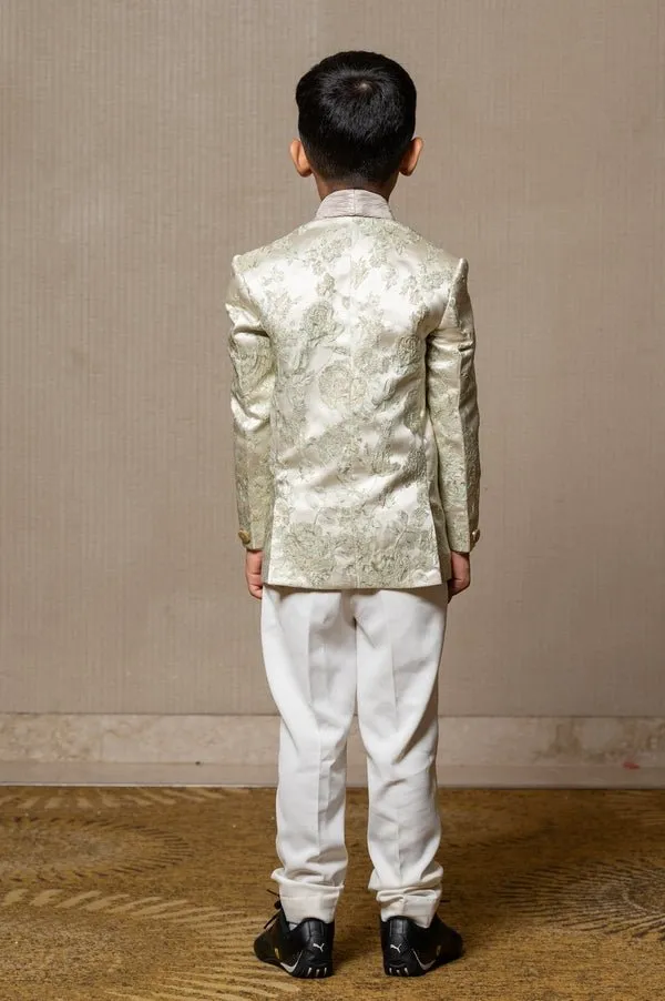 Elegant brocade suit jacket with floral patterns paired with crisp white trousers and a classic ivory shirt for a regal and sophisticated look.