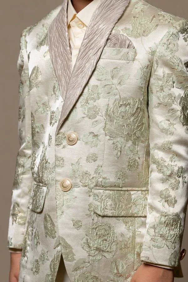 Elegant brocade suit jacket with floral patterns paired with crisp white trousers and a classic ivory shirt for a regal and sophisticated look.