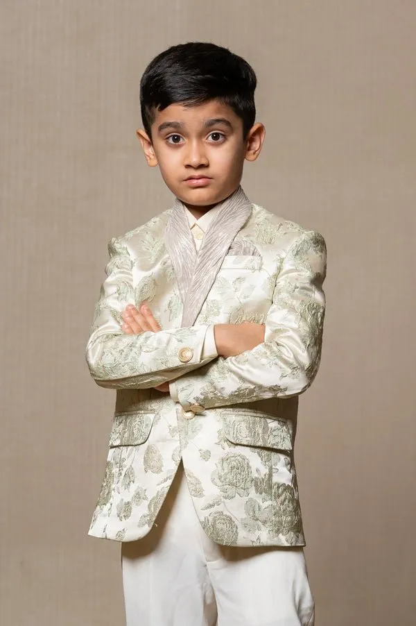 Elegant brocade suit jacket with floral patterns paired with crisp white trousers and a classic ivory shirt for a regal and sophisticated look.